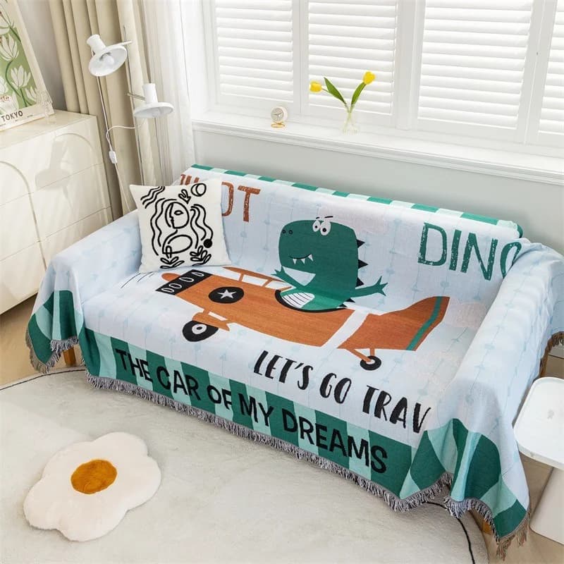 Sofaüberwurf mit Cartoon-Dinosaurier und Quasten
